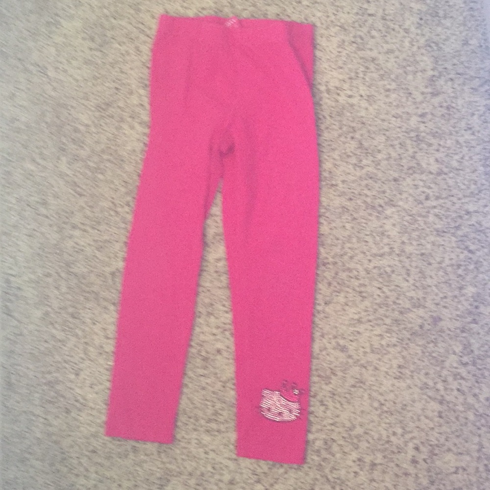 Pink leggings with a cat on the ankle part of pant